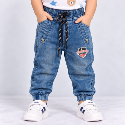 OlioKids boys blue denim jogger pants with elastic waist, drawstring, front pockets and football graphic detail